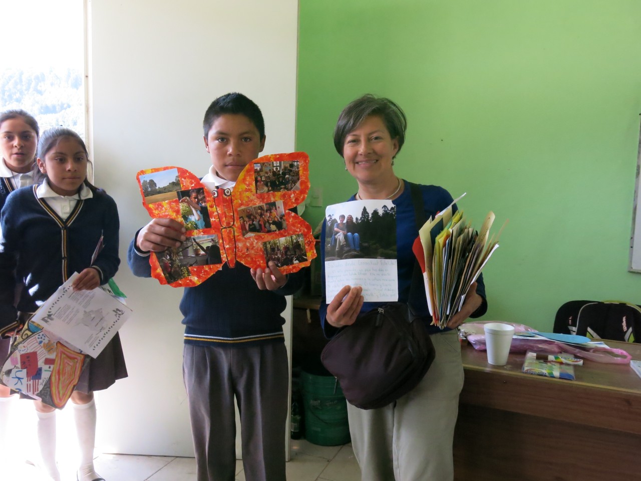 A student proudly shows his Ambassador monarch while posing with Estela.