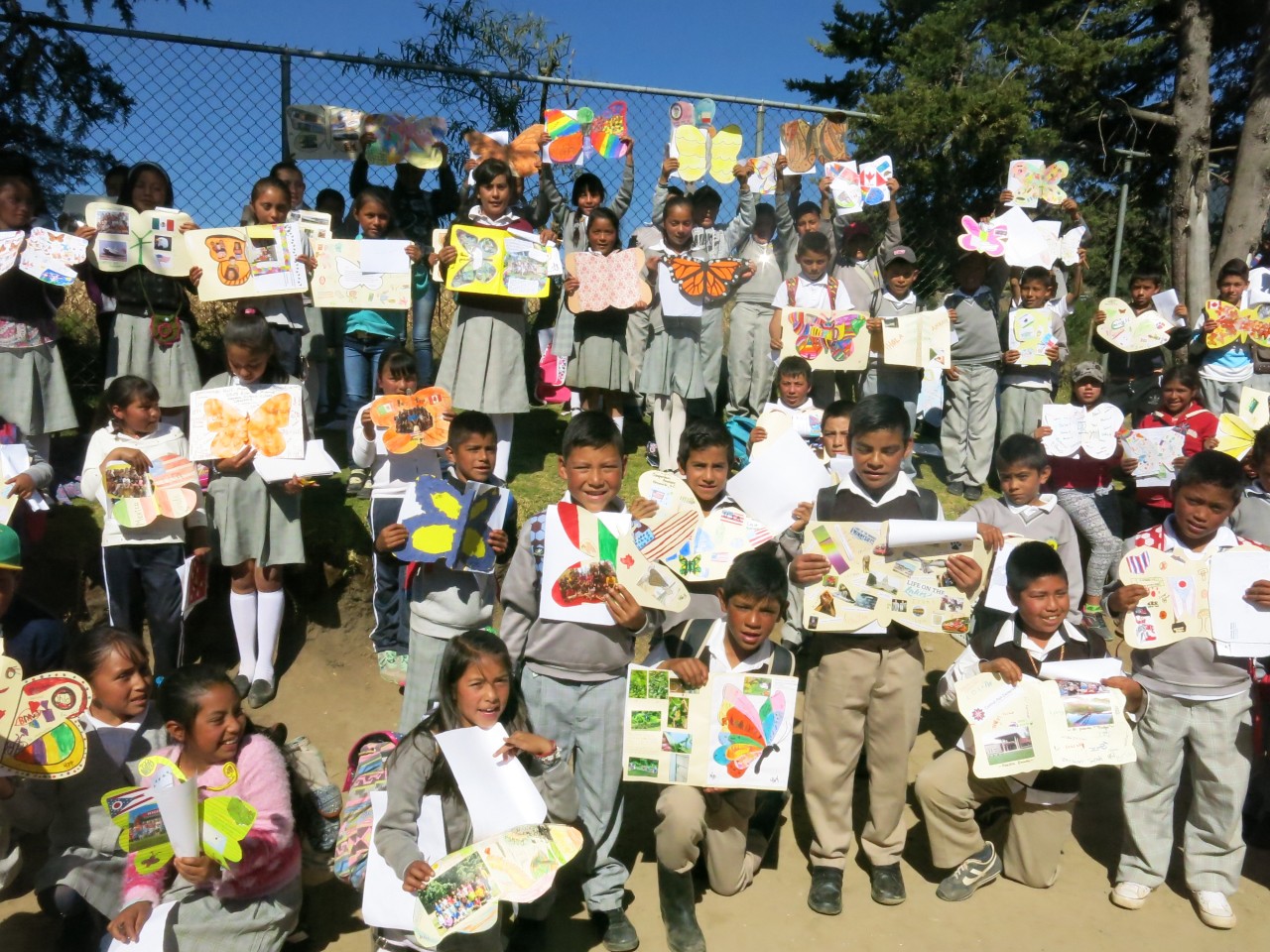 Proud students sharing their butterflies in this class photo.