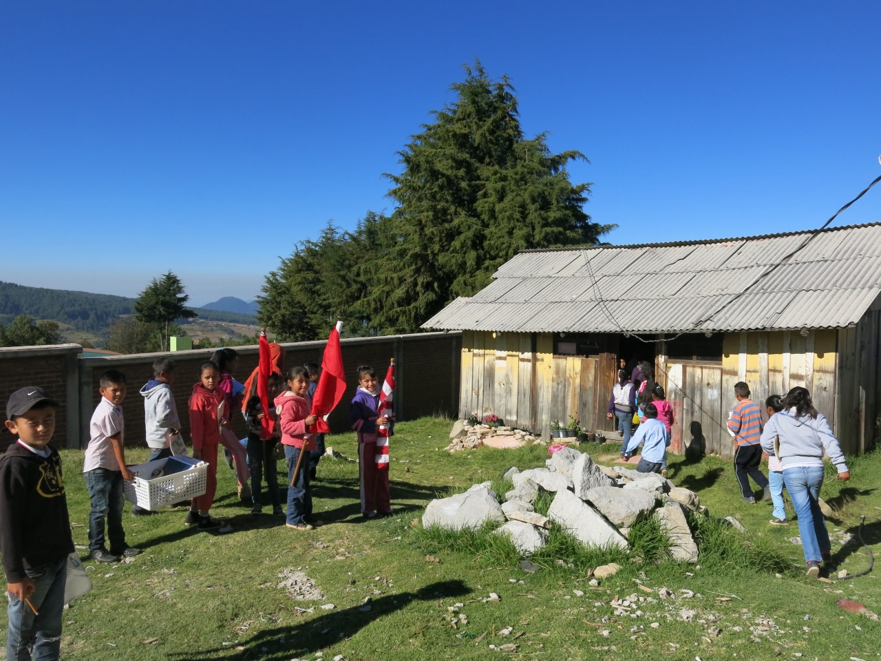 Students happily help carry the Symbolic Monarchs, flags, and teaching materials into their classroom.